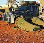 green canvas swag in outback australia set up with car at camp site landor races