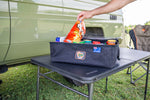 camping bag with food stored inside on table near vehicle